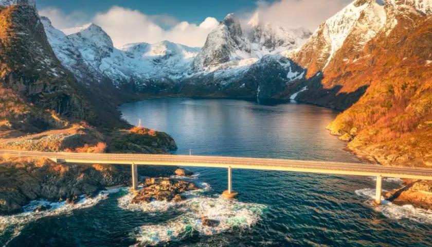 Mosty nad fiordem, ośnieżone góry, złote światło. Idealny czas na podróż do Norwegii to jesień, kiedy krajobraz jest tak piękny.