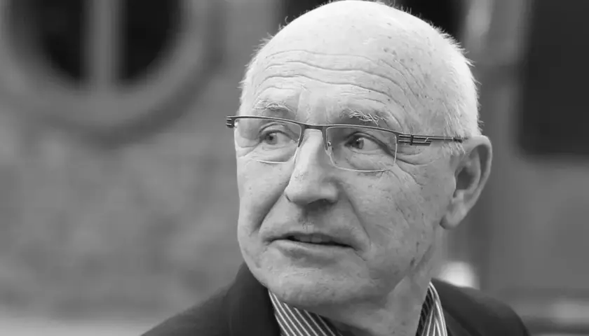 Portret starszego mężczyzny w okularach, który wygląda jak doświadczony lenczyk trener piłkarski, zamyślony.
