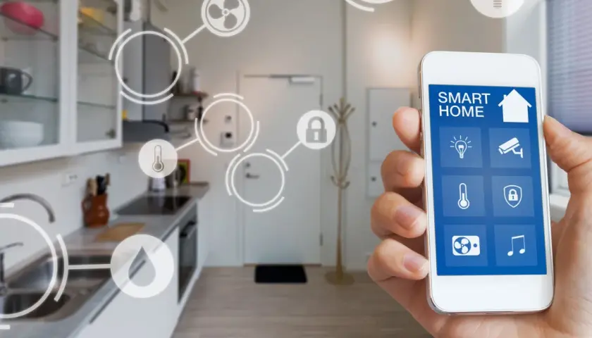 Smartfon steruje inteligentnym domem, pokazując ikony urządzeń. To właśnie dzięki technologii takiej jak zigbee co to jest, możemy zarządzać domem zdalnie.
