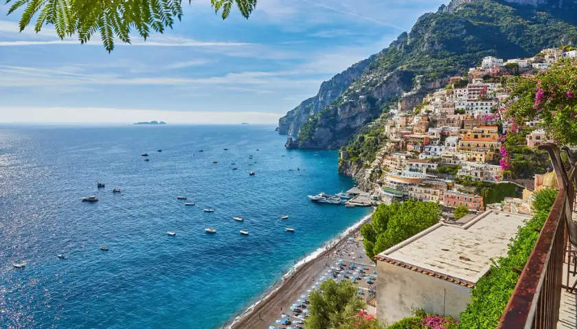 Positano, un luogo perfetto per un weekend con bambini in Campania. Case colorate aggrappate alla scogliera, mare blu e spiaggia animata.
