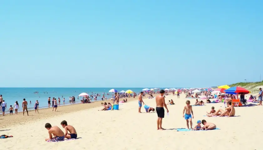 Tłum ludzi na piaszczystej plaży, szukających odpowiedzi na pytanie: gdzie najbliżej nad morze z Warszawy.