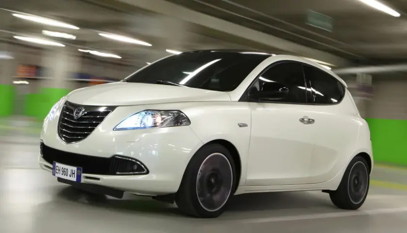 Lancia Ypsilon a metano in movimento in un parcheggio.