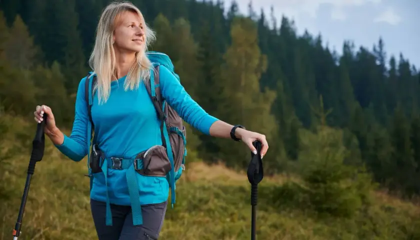 Kobieta z plecakiem i kijki nordic walking – jak dobrać idealne do wędrówki po górach.