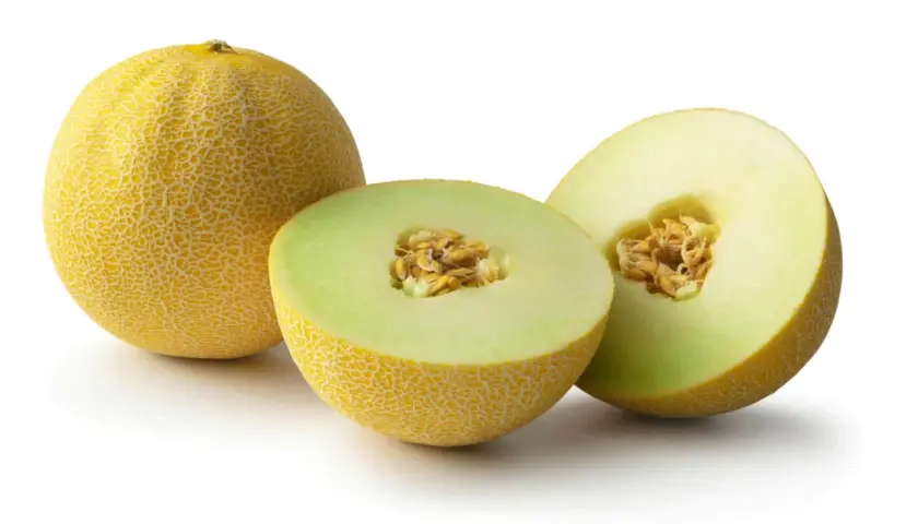En hel och två halvor av en saftig cantaloupemelon med synliga kärnor. Perfekt för en svalkande sommardessert.