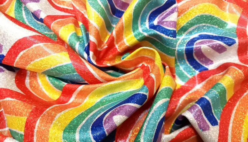 Tissu lycra déf. aux couleurs arc-en-ciel, scintillant et drapé, évoquant la joie et la célébration.