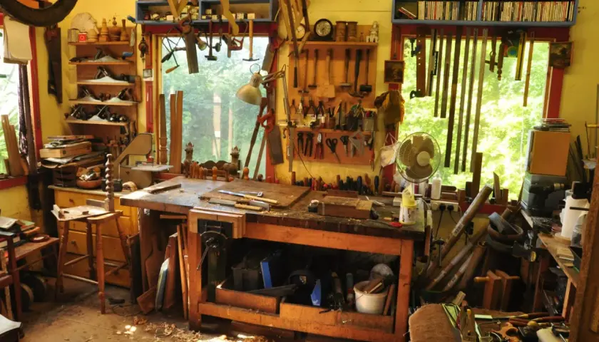 Un laboratorio pieno di attrezzi mostra come si lavora il legno: pialle, seghe, scalpelli e un banco da lavoro pronto per creare.