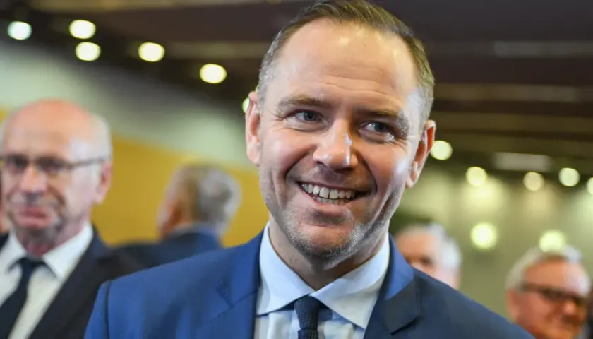 Uśmiechnięty mężczyzna w garniturze, być może przyszły kandydat na następcę Andrzeja Dudy w walce o pałac prezydencki.
