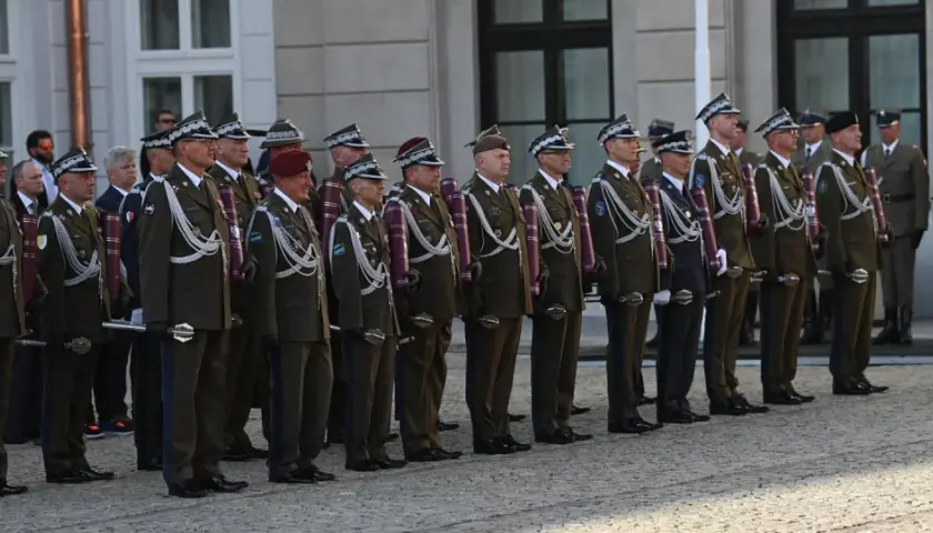 Uroczystość wręczenia nominacji na stopnie generalskie w Polsce. Wojskowi w galowych mundurach stoją w szeregu, prezentując swoje honory.