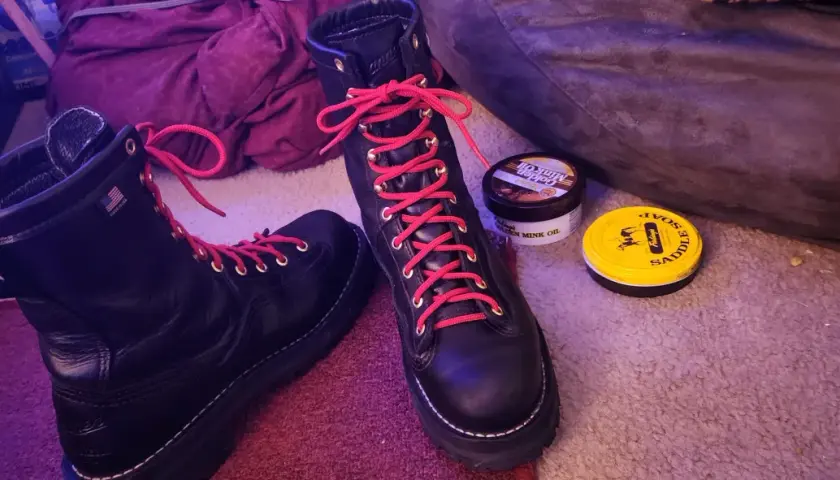 Black hiking boots with bright red laces, ready for adventure. Why do hiking boots have red laces? For a pop of color and to stand out on the trail!