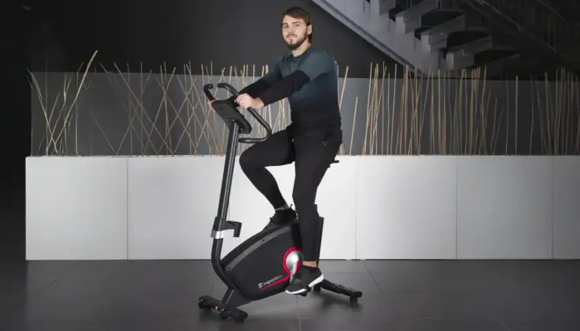 Mężczyzna ćwiczy na rowerze stacjonarnym, jednym z wielu rodzajów rowerów stacjonarnych dostępnych na rynku.