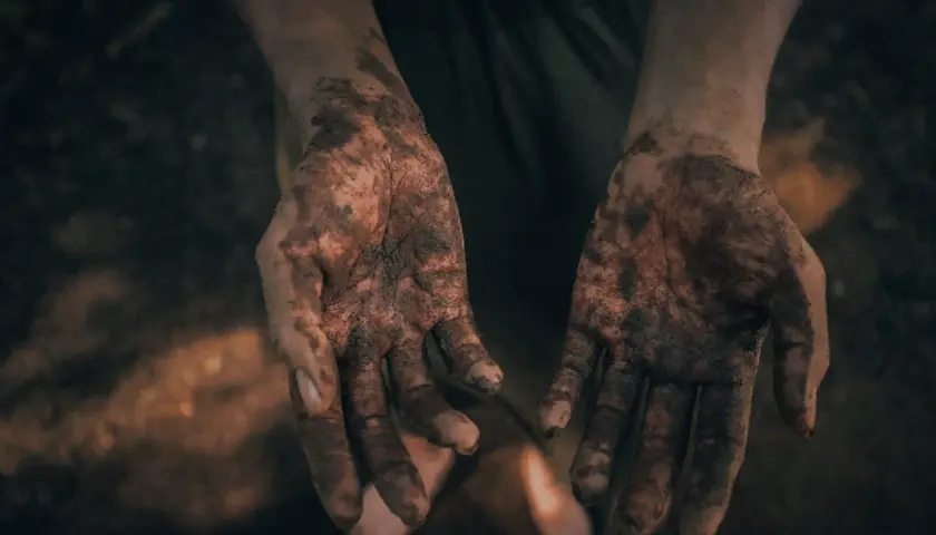 Brudne dłonie, jak po próbie molestowania, symbolizują walkę i potrzebę oczyszczenia.