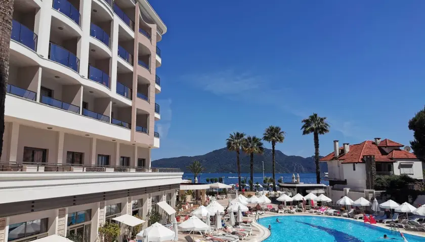 Fajny hotel nad morzem z basenem i palmami. Słoneczny dzień, idealny na wakacje.