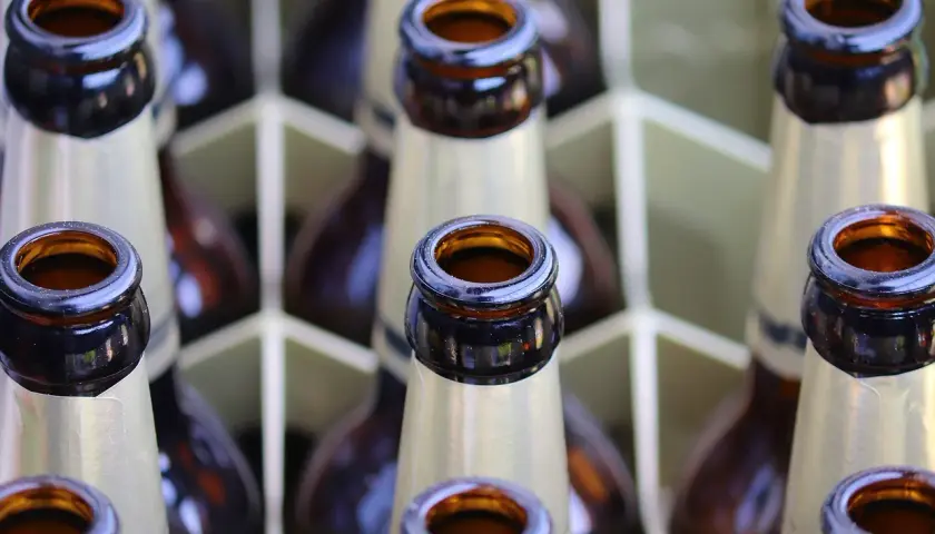 Bouteilles de bière brune française alignées dans un casier. Le col des bouteilles est visible, prêt à être dégusté.