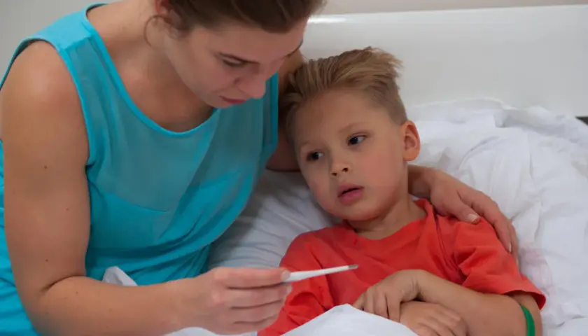 Mamma controlla la febbre al bambino, preoccupata per la quarta malattia.