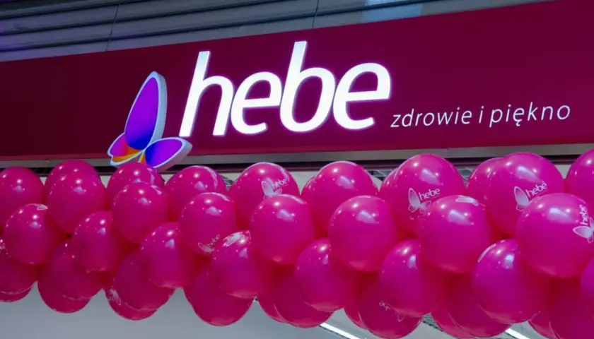 Logo Hebe z motylem i girlanda różowych balonów.