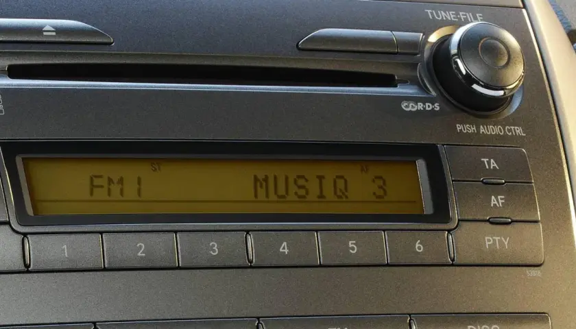 Radio samochodowe z wyświetlaczem RDS, pokazującym "FM 1 MUSIQ 3". Przyciski numeryczne i sterowanie.