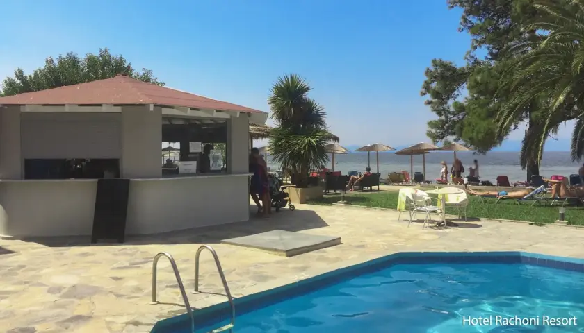 Basen i bar przy plaży w Hotel Rachoni Resort. Słońce, palmy i morze tworzą idealne wakacje.