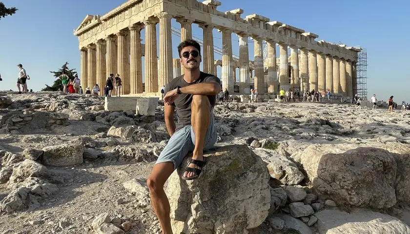 Hombre sentado en la Acrópolis, disfrutando de la vista del Partenón. ¡Una parada obligatoria si buscas qué ver en Atenas en 2 días!
