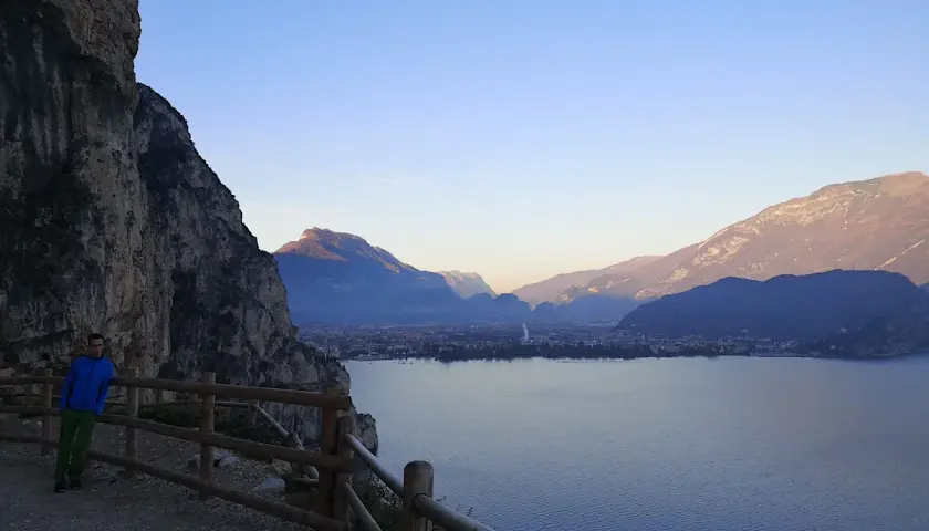 Spacer po ścieżce na zboczu Monte Brione z widokiem na jezioro i góry.