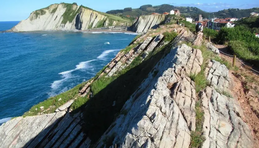Acantilados vascos, como los de "Ocho Apellidos Vascos", con el mar azul y un sendero rocoso.