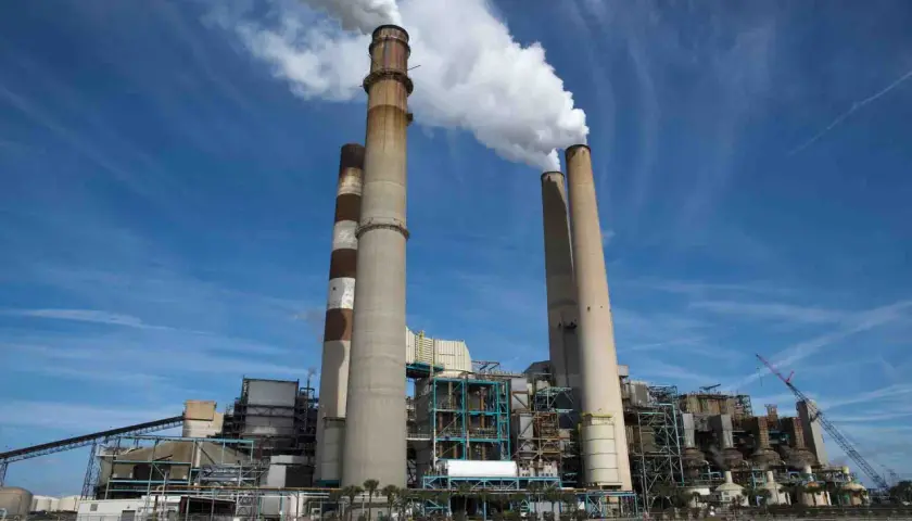 Chimeneas de una central eléctrica emiten vapor, un signo del calor industrial que genera energía.