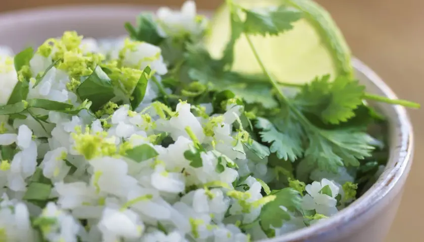 En skål med fluffigt mexikanskt ris, toppat med färsk koriander och limezest. Perfekt som tillbehör till din favorit tacorätt.