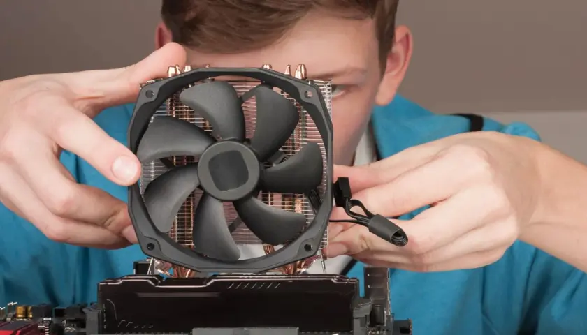 Junge Person montiert CPU-Kühler. Möglicher Fehler: cpu fan speed detection error.