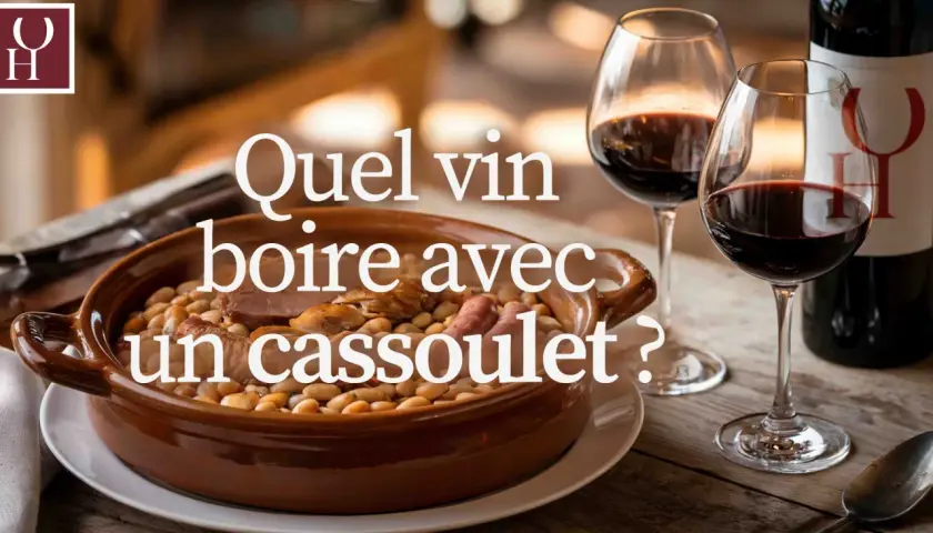 Un plat de cassoulet fumant, deux verres de vin rouge et une bouteille. La question se pose : quel vin boire avec un cassoulet ?