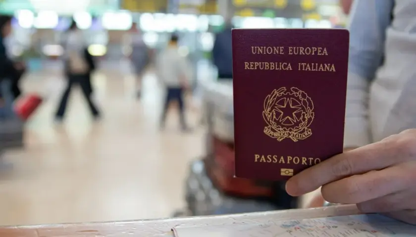 Włoski paszport w dłoni, gotowy do podróży po krajach bez paszportu w strefie Schengen.