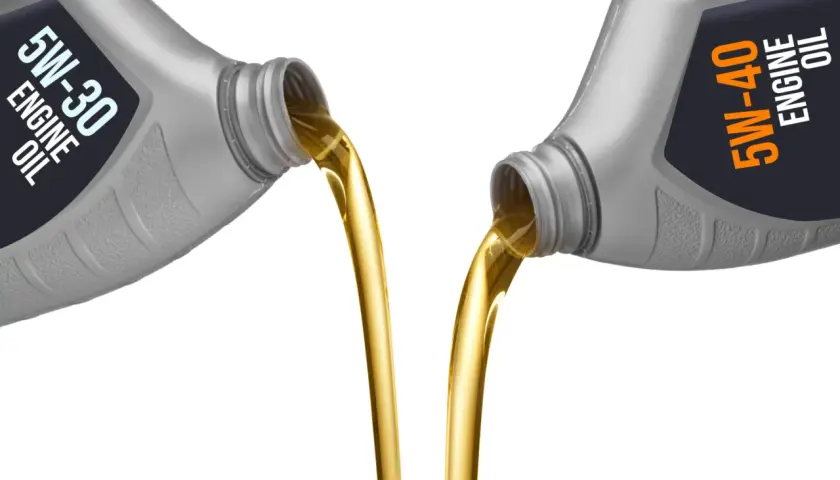 Aceite 5w30 vs 5w40: dos botellas vierten aceite dorado, mostrando la diferencia de viscosidad.