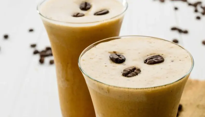 Due bicchieri di cremoso sorbetto al caffè, guarniti con chicchi tostati, invitano a una pausa rinfrescante.