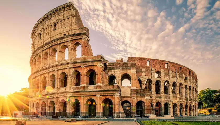 Le Colisée de Rome baigné par le soleil levant, un monument emblématique pour toute visite à Rome.