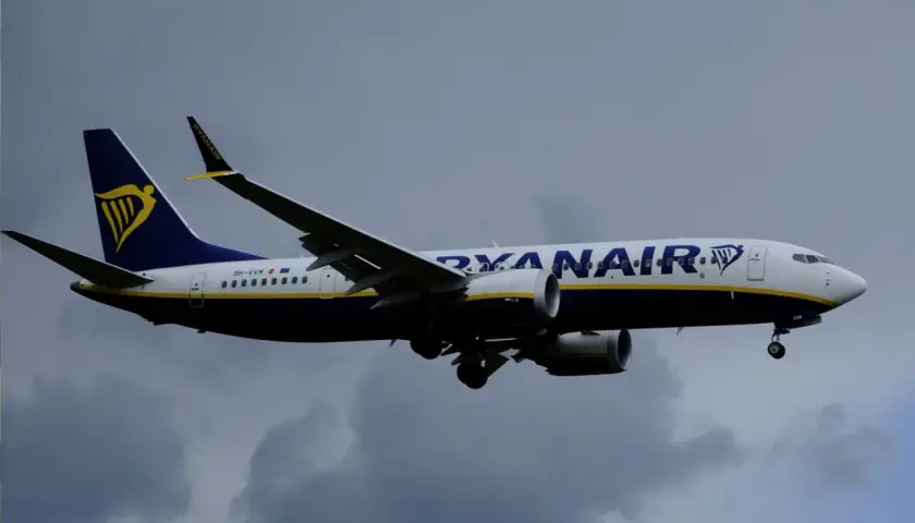 Samolot Ryanair z logo i napisem "RYANAIR" na tle chmur. Czyżby pasażerowie planowali Ryanair zmiana nazwiska?