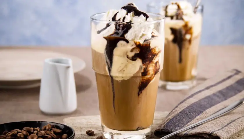 Ein erfrischender Eis Kaffee mit Sahne und Schokoladensirup, perfekt für heiße Tage.