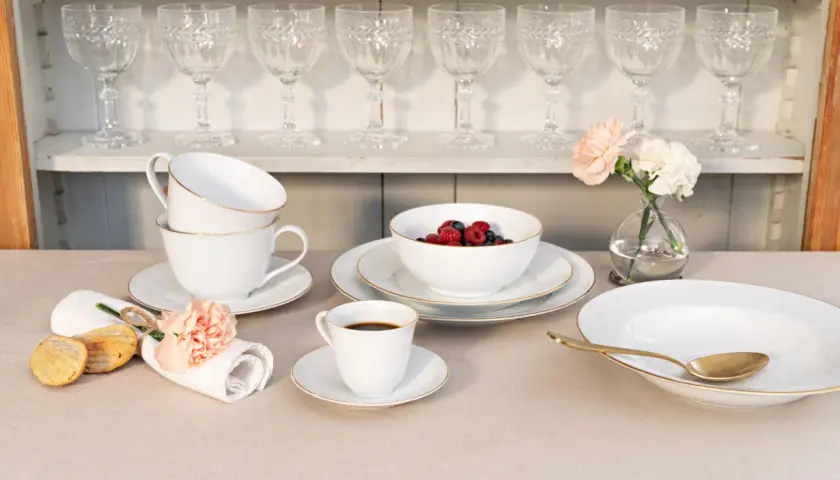 Elegantes schwedisches Porzellan mit goldenen Akzenten, serviert mit Beeren, Kaffee und Gebäck.