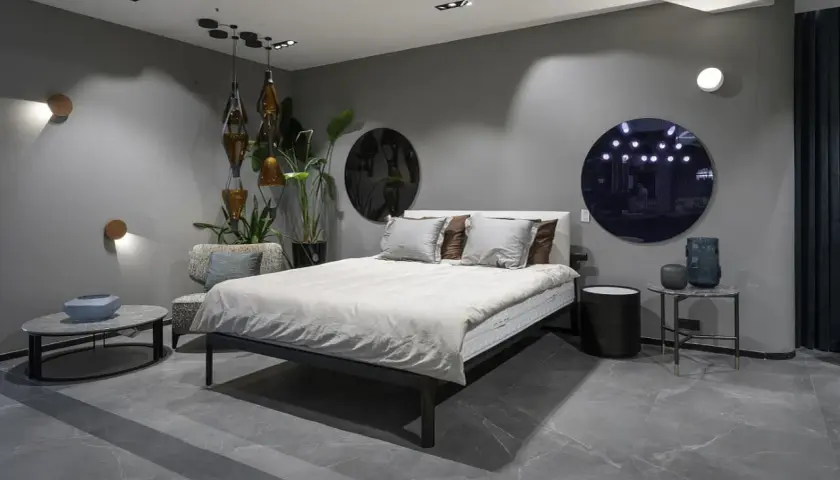 Nowoczesna sypialnia z kinkietami, łóżkiem i designerskimi dodatkami.