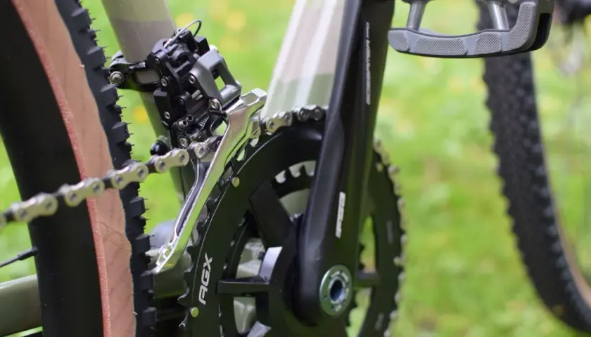 Zbliżenie na rower, widoczny mechanizm korbowy, łańcuch i przerzutka. Czas na czyszczenie łańcucha rowerowego, by jazda była płynna.