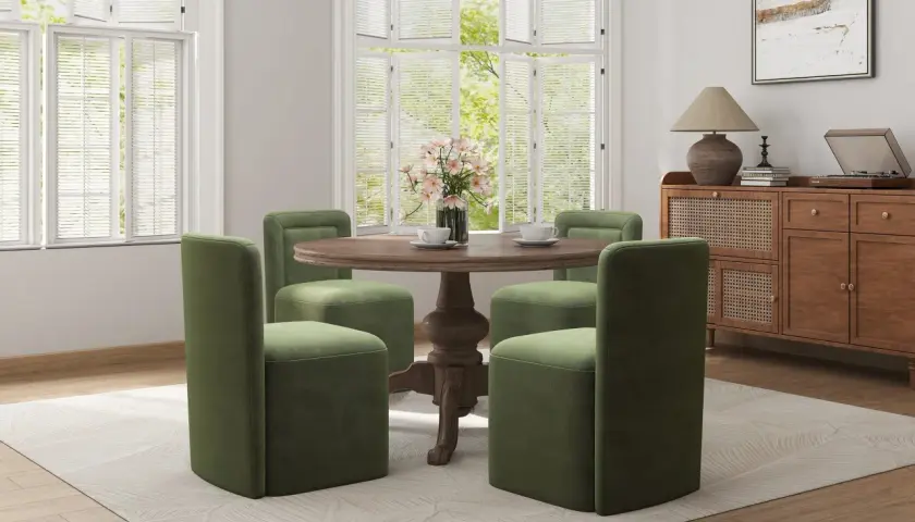 Four green chairs with plush, straight backs surround a round wooden table, showcasing modern types of chair backs.
