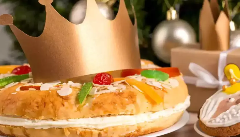 Un gâteau pour accompagner le champagne, décoré de fruits confits et d'une couronne dorée, prêt pour une fête royale.