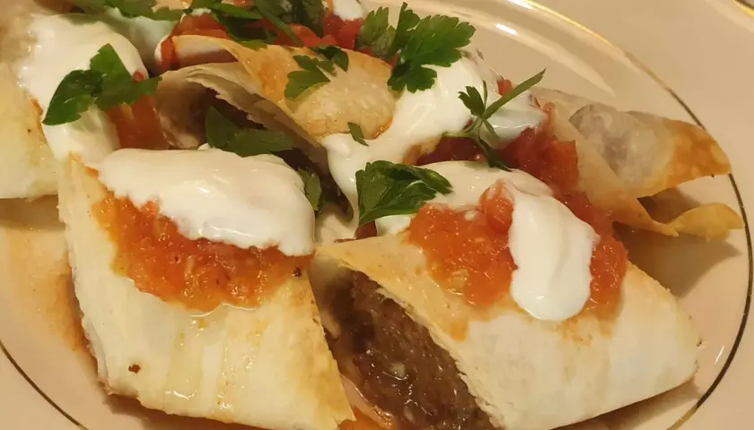 Beyti kebab med yoghurt, tomatsås och persilja. En läcker rätt som ser ut att smaka fantastiskt.