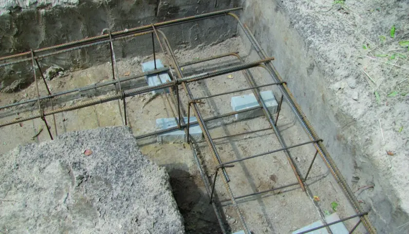 Zbrojenie fundamentów w narożnikach, gotowe do zalania betonem. Widać staranne łączenie zbrojenia w narożnikach.