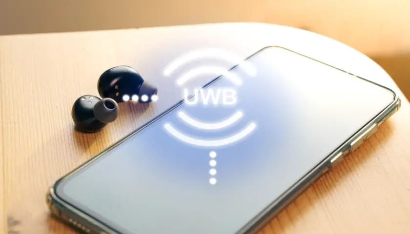 Auriculares inalámbricos y un smartphone con el símbolo UWB que es una tecnología de comunicación.