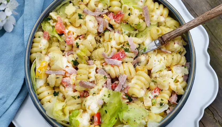 En stor skål med krämig pastasallad med skinka, tomat och sallad. Perfekt dressing till pastasallad för en sommarlunch.