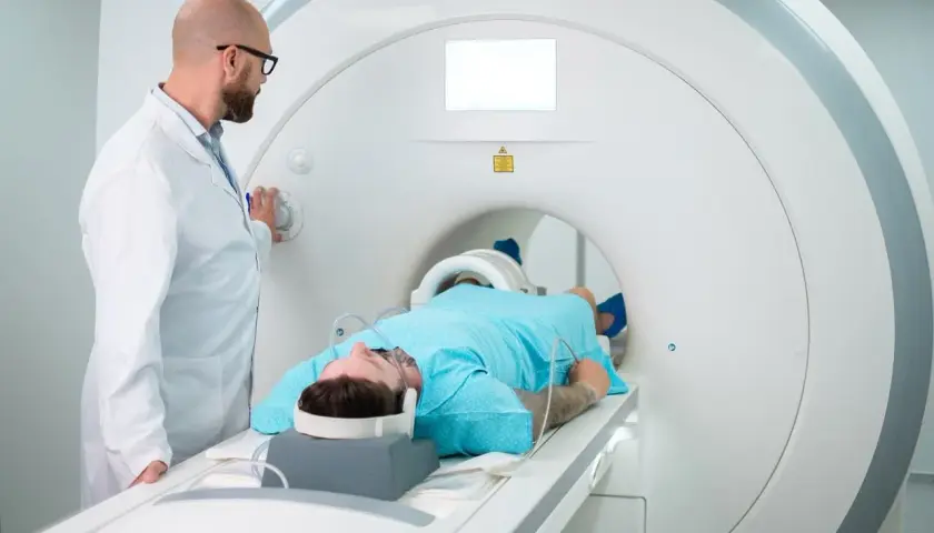Lekarz nadzoruje pacjenta w skanerze MRI. Czas badania zależy od jego celu.
