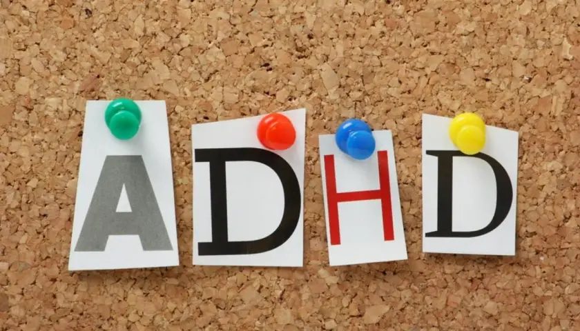 Litery "ADHD" przypięte do korkowej tablicy. Czy ADHD jest dziedziczne? To pytanie nurtuje wielu.