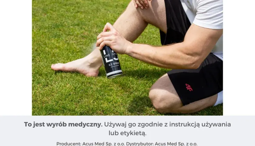 Mężczyzna stosuje spray chłodzący przeciwbólowy na nogę siedząc na trawie.