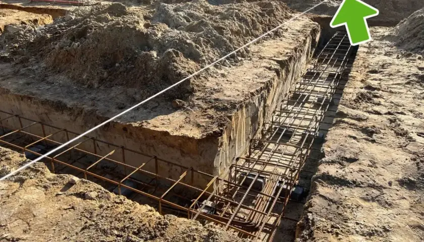 Wytyczenie budynku: zbrojenie ławy fundamentowej w wykopie. Widać sznur geodezyjny do precyzyjnego wyznaczenia.