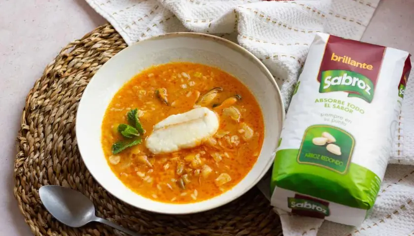Sopa de pescado con arroz sencilla, con trozos de pescado, mejillones y arroz redondo Sabroz, decorada con menta.