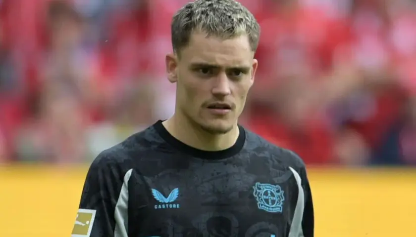 Bramkarz Bayer Leverkusen w nowym stroju, gotowy na kolejne transfery i sukcesy.