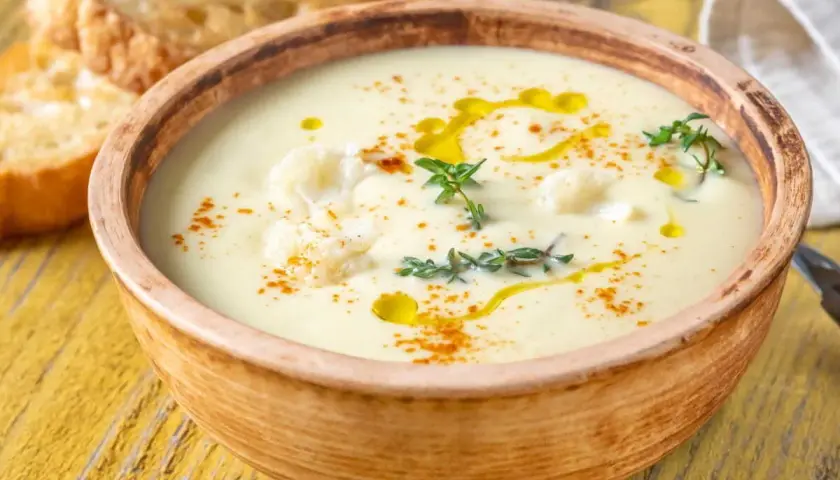 Un onctueux potage Dubarry, garni de chou-fleur, d'huile d'olive et de thym, servi avec des toasts grillés.